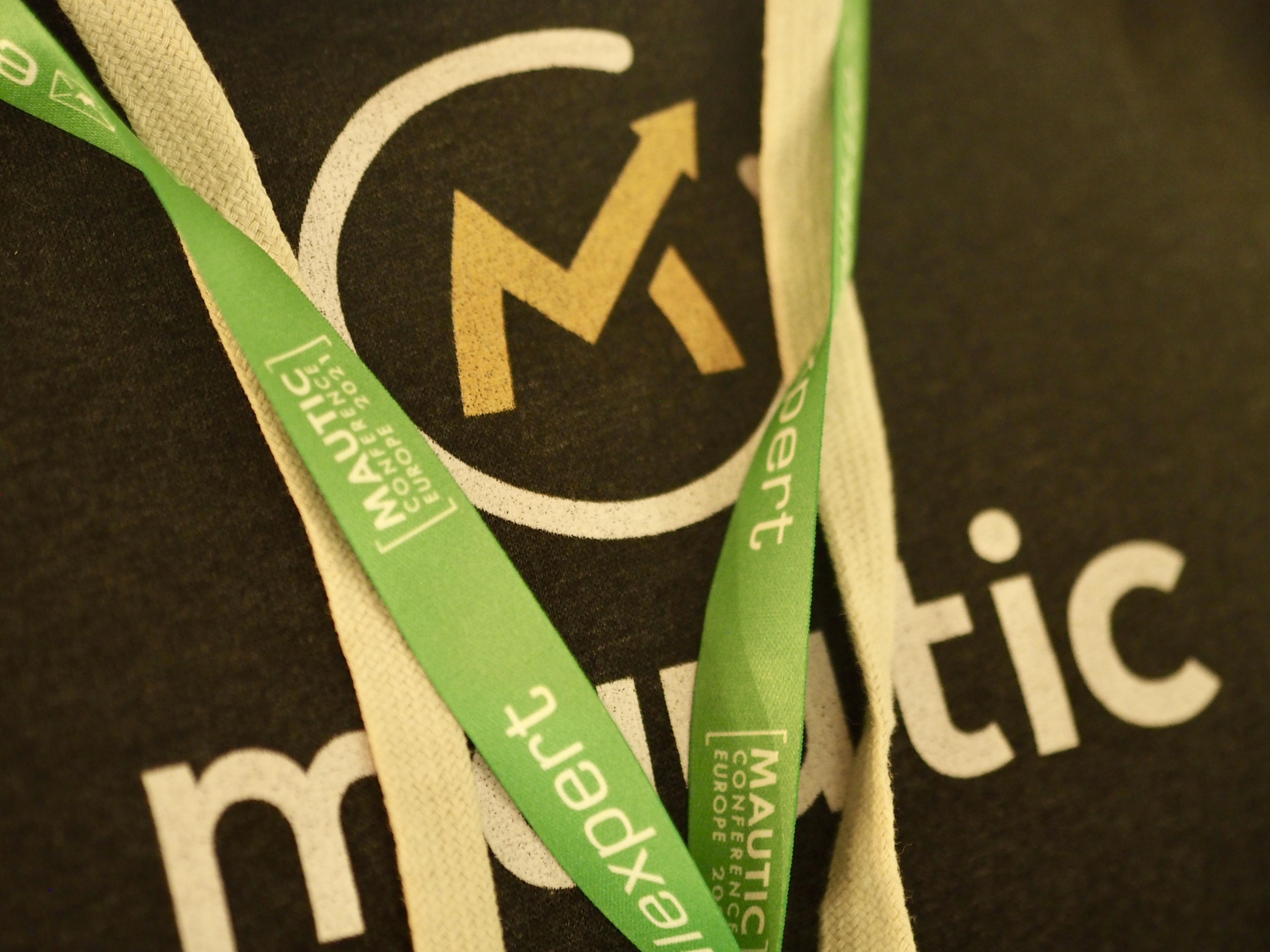 Photo of someone wearing a Mautic hoodie with the green event lanyard showing