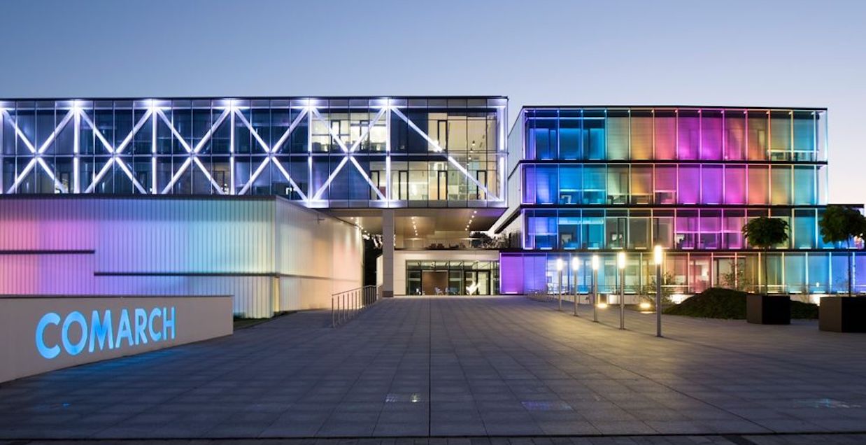 Photo of the comarch office building illuminated in the colours of the rainbow.