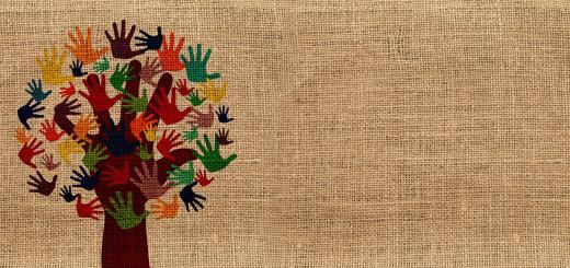 Painting of a tree with leaves of multiple colour handprints on a hessian canvas background