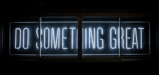 Neon sign saying 'Do something great' on a dark background